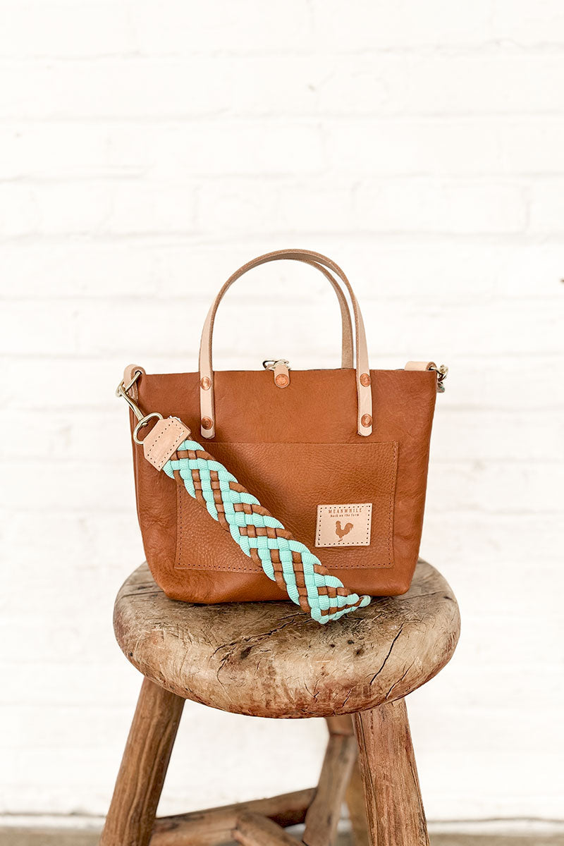 Light blue and brown woven crossbody strap folded in half