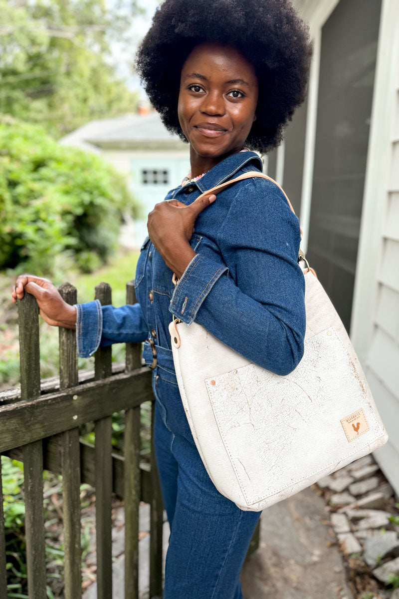 Model wearing white shoulder bag with extra cream colored strap