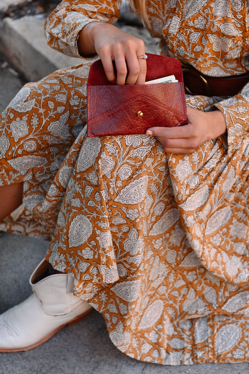 Model looking in small ruby red leather clutch