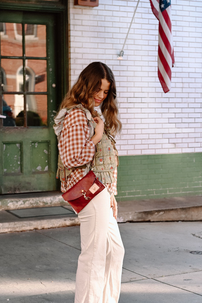 Model looking in small red leather clutch