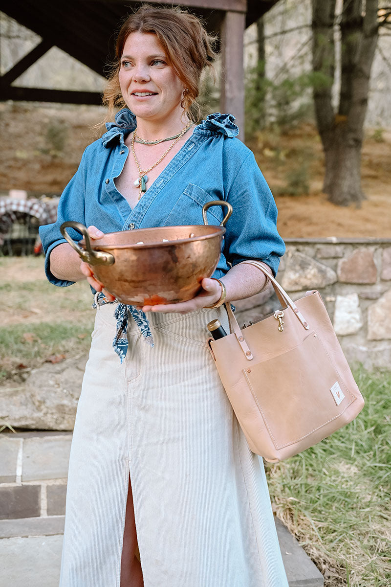 Woman holding natural Virginia leather small tote bag