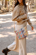 Model wearing floral quilted bag with hi length cream colored handles.