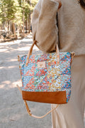 Picture of quilted floral print bag with cream color straps and tan leather bottom