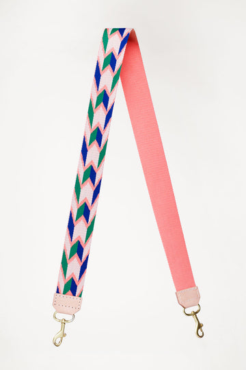 Pink with green and blue design webbing crossbody strap with a cream end color folded in half 