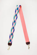 Pink with green and blue design webbing crossbody strap with a brown end color folded in half 