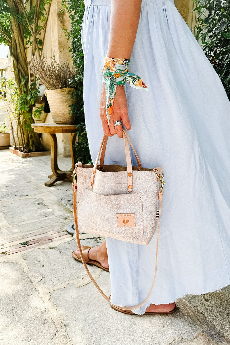 Girl wearing a dress holding a white birch leather small purse 