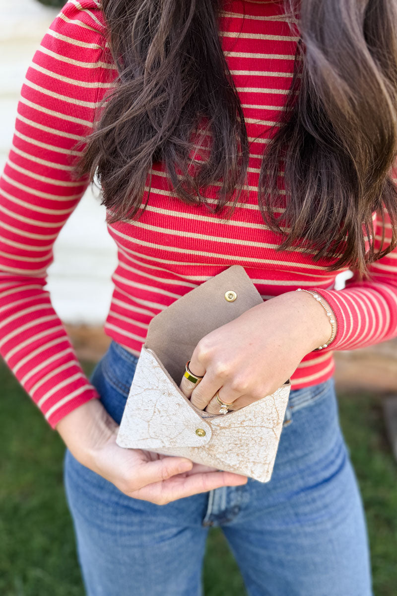 Model reaching inside small birch white leather keepsake clutch