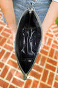 Girl showing black inside lining of a small leather pouch